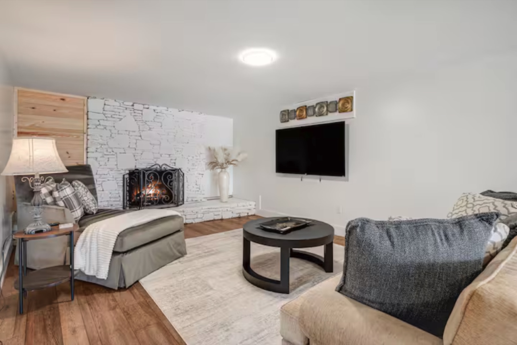 Dated brown living room with stone fireplace before design